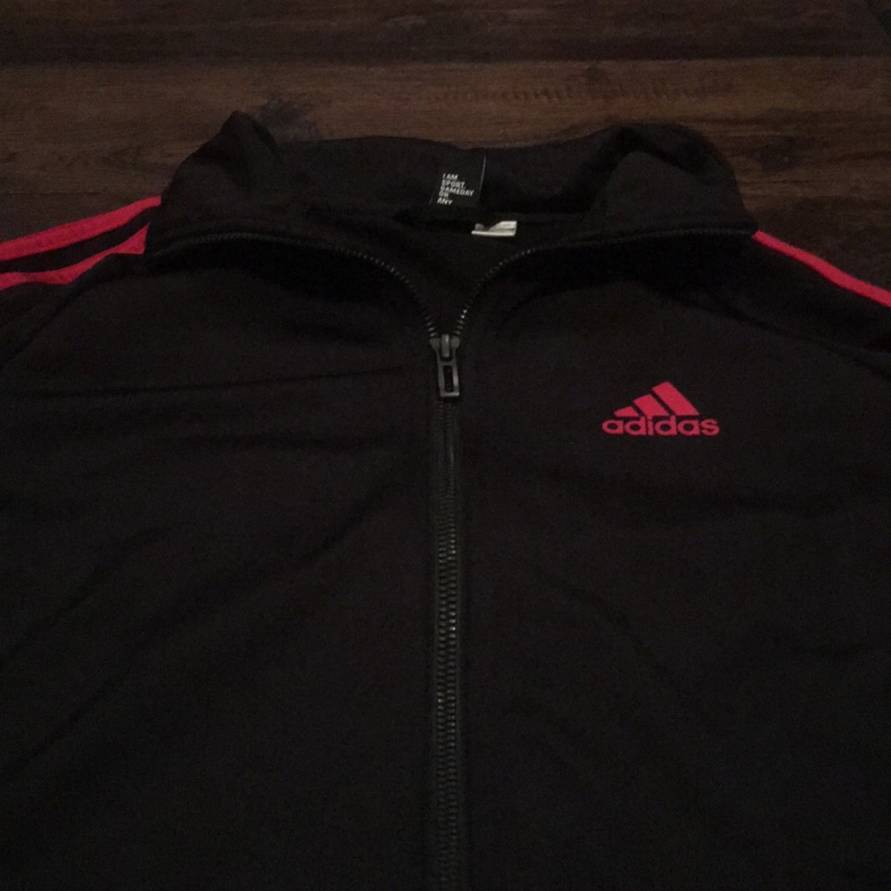 An adidas jacked with red stripes